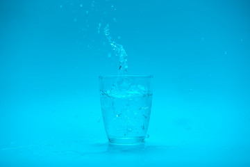 Naklejka na ściany i meble Glass of water with splash isolated on white background
