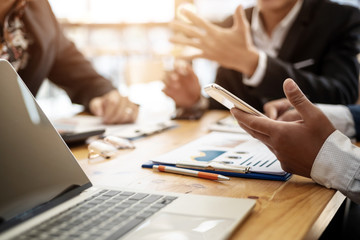 Business man using phone while meeting for share financial report in conference room . Accounting concept.