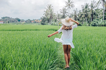 Naklejka na ściany i meble Young girl walking in rice field in Bali