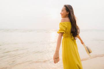 Fototapeta na wymiar Portrait beautiful young asian woman walk on the beach and sea ocean with smile happy relax