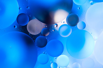 oily drops  in water with colorful background, close-up 