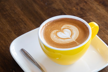 Coffee cup with latte art foam on wood table in coffee shop with copy space.Coffee is one of the most popular beverages.Improve Energy Levels and Burn Fat