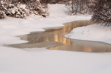 Winter in the park with beautiful reflection in a lake with frozen water