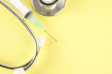 Medical Concept with stethoscope ,syringe  isolated on yellow background. Copy Space