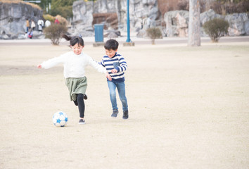 公園でサッカーをする子供