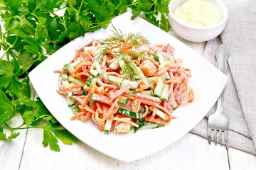 Salad of sausage and spicy carrots with mayonnaise on light table