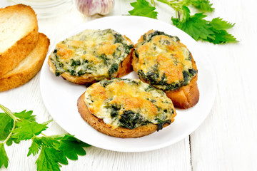 Sandwich of nettle and cheese in plate on wooden board
