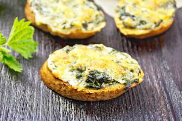 Sandwich of nettle and cheese on dark wooden board