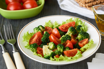 Salad with broccoli and cherry tomatoes in a white bowl