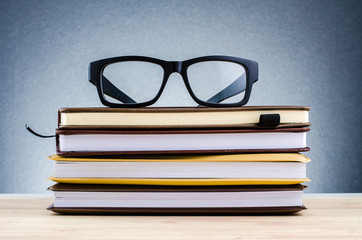 Education concept, spectacles on stack of books over beautiful gradient background with reverberation
