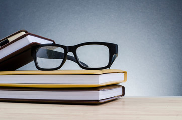 Education concept, spectacles on stack of books over beautiful gradient background with reverberation