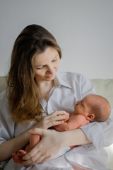 Pretty woman holding a newborn baby in her arms