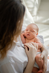 Pretty woman holding a newborn baby in her arms