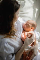 Pretty woman holding a newborn baby in her arms