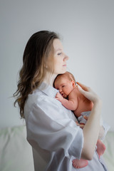 Pretty woman holding a newborn baby in her arms