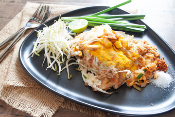 Pad Thai or stir-fried noodles with shrimp and egg on black plate