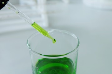 Pipette dropping a sample into a test tube, -close up - image