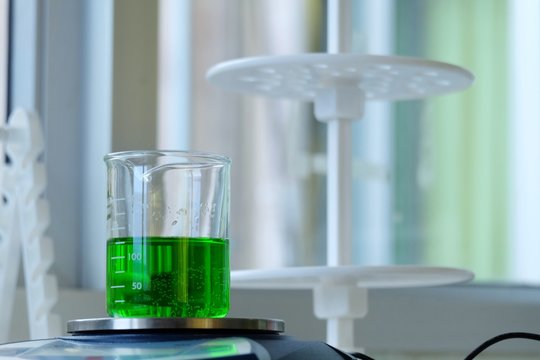 Scientists are drops of solution into a beaker containing chemicals scales with Digital weighing scales. - Image