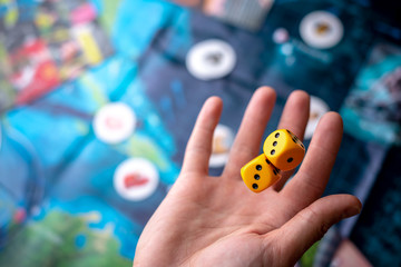 The hand throws two yellow dice on the playing field. Gaming moments in dynamics. Concept Board...