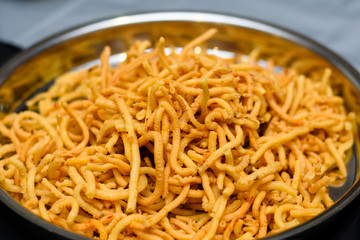 Srilankan spicy snack mixture in a silver plate.