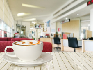 Smile coffee cup on white wood table with car showroom background.