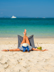 Woman enjoying her holidays on a transat at the tropical beach