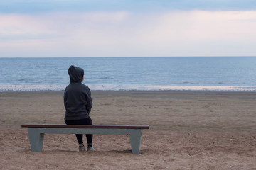 Naklejka na ściany i meble lonely thoughtful girl sitting on a bench