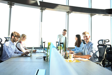 Obraz premium Young modern colleagues in smart casual wear working together while spending time in the creative office.