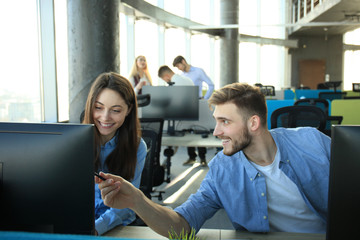 Obraz premium Young modern colleagues in smart casual wear working while spending time in the office.