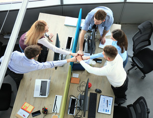 Top view of young modern colleagues in smart casual wear working together while spending time in the office.