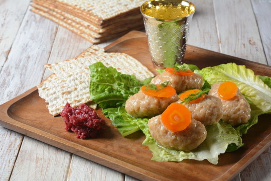 Passover Pesach traditional Jewish food - gefilte fish with, lettuce, carrots, horse radish and matzah. Passover celebration concept