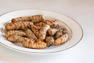 Roots of Turmeric (a flowering plant of the ginger family, Zingiberaceae) used in cooking either fresh or grounded into a powder as a coloring and flavoring agent/spice.