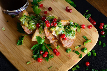 Meat with greens and berries and wine. Meat on a wooden board