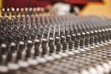 Detail of Analog studio mixing console with blurred background