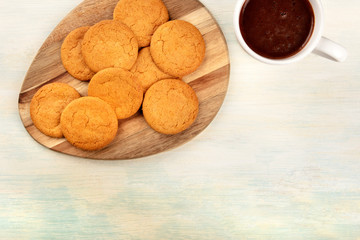 A closeup of ginger cookies, shot from above with a cup of hot chocolate and a place for text