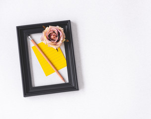 vintage space black picture frame and note with rose flower and pencil