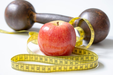 dumbbell Apple and meter the concept of a healthy lifestyle