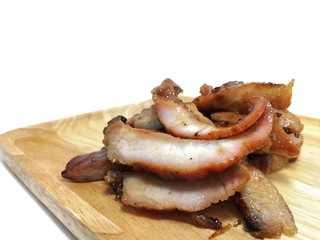 Grilled pork neck in a wooden tray on a white background