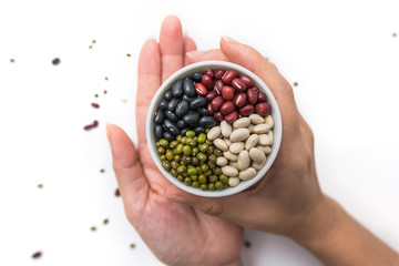 Beans in a white cup on a woman's hands