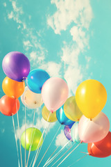 Colorful festive balloons over blue sky with a retro vintage instagram filter effect.
