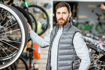 Portrait of a handsome man as a buyer or salesperson at the bicycle shop
