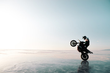 guy riding on one wheel on a bike