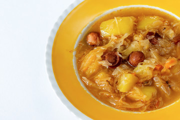 Cabbage soup in yellow plate.
