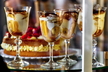 Sweet creams in goblets in glass show-case.