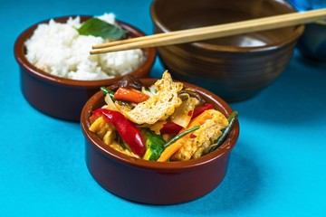Tofu with vegetable, rice and chopstick.