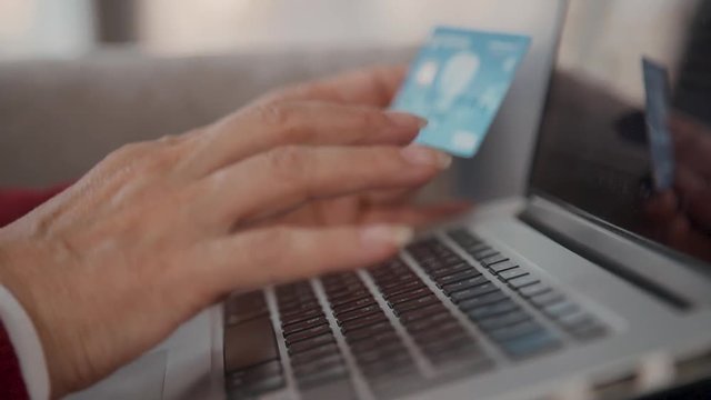 Close Up Retired Female Hands Typing Credit Card Number On Laptop Computer Keyboard.