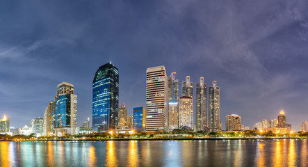 Obraz na płótnie Canvas Panorama,Modern buildings and business district cityscape from urban park,night view,cityscape image of Benchakitti Park,Bangkok,Thailand