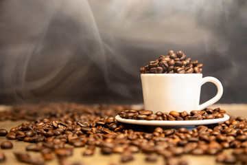 Roasted coffee beans in a cup of hot espresso,arabica beans and robusta beans mixed,medium roasted to dark roasted  in cafe shop,for espresso drink,hot steam and smoke in the morning,copy space