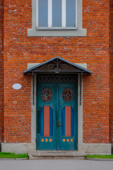 Wooden door on the red brick stone facade of building