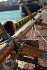 Sailing yacht repair. The mast from the yacht lies on the ground in the port.